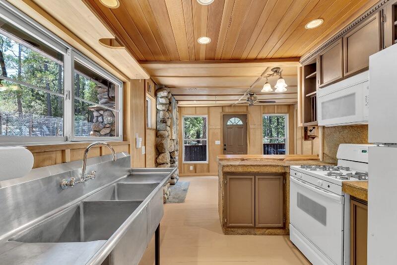 27240 Saunders Meadow Road Idyllwild, CA 92549 - Photo 23 of 51 a kitchen with kitchen island a large window cabinets and stainless steel appliances