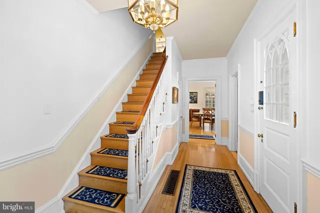 a view of staircase with lots of frames on wall and a large window