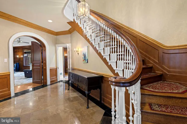 a front view of a brick house with a yard and potted plants