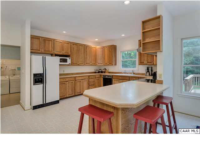 121 Vincennes Road Charlottesville, VA 22911 - Photo 10 of 42 a kitchen with stainless steel appliances kitchen island granite countertop a dining table chairs refrigerator and sink