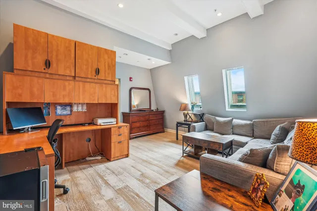 a living room with stainless steel appliances furniture and a kitchen view