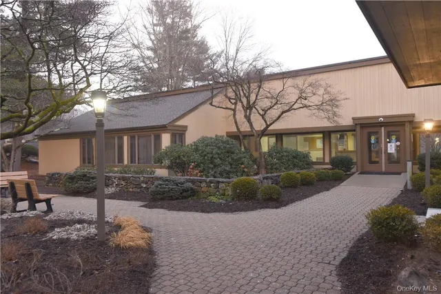 a view of a house with a yard and large tree