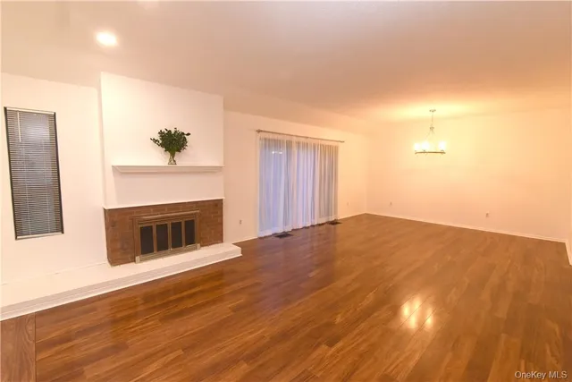 a view of a livingroom with wooden floor and a fireplace