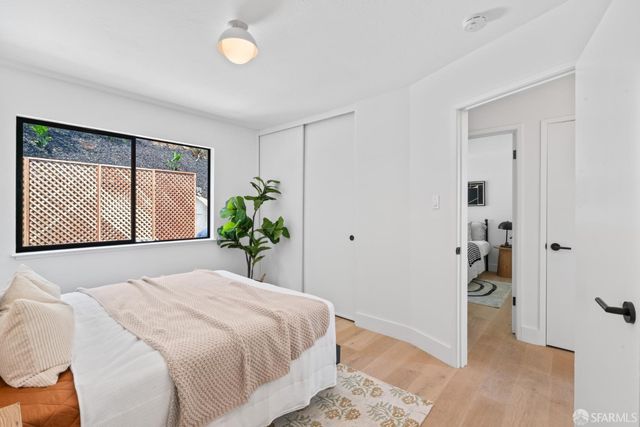 a bedroom with two beds and potted plant