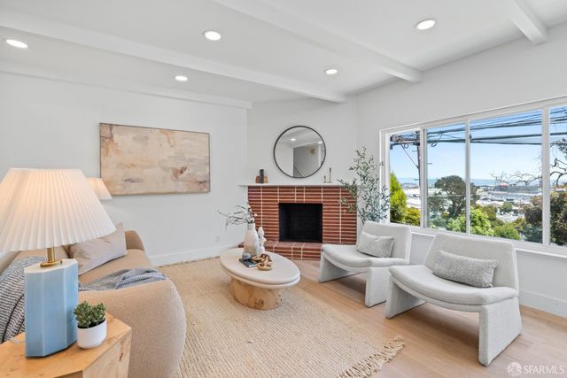 a living room with furniture a fireplace and a large window