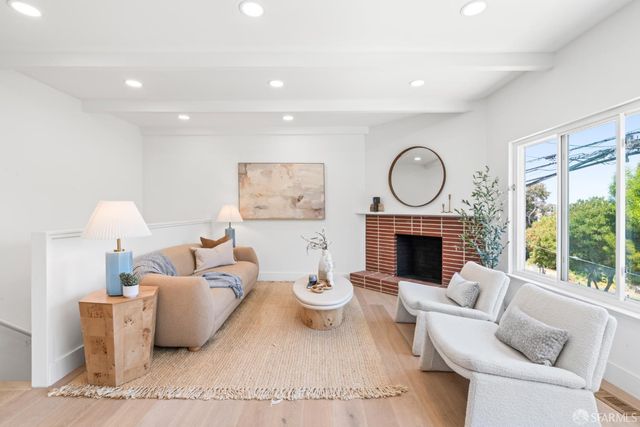 a living room with furniture a fireplace and a large window