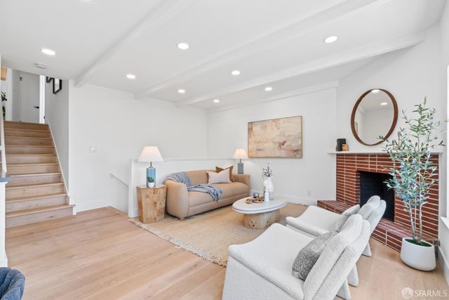 a living room with furniture a fireplace and a wooden floor