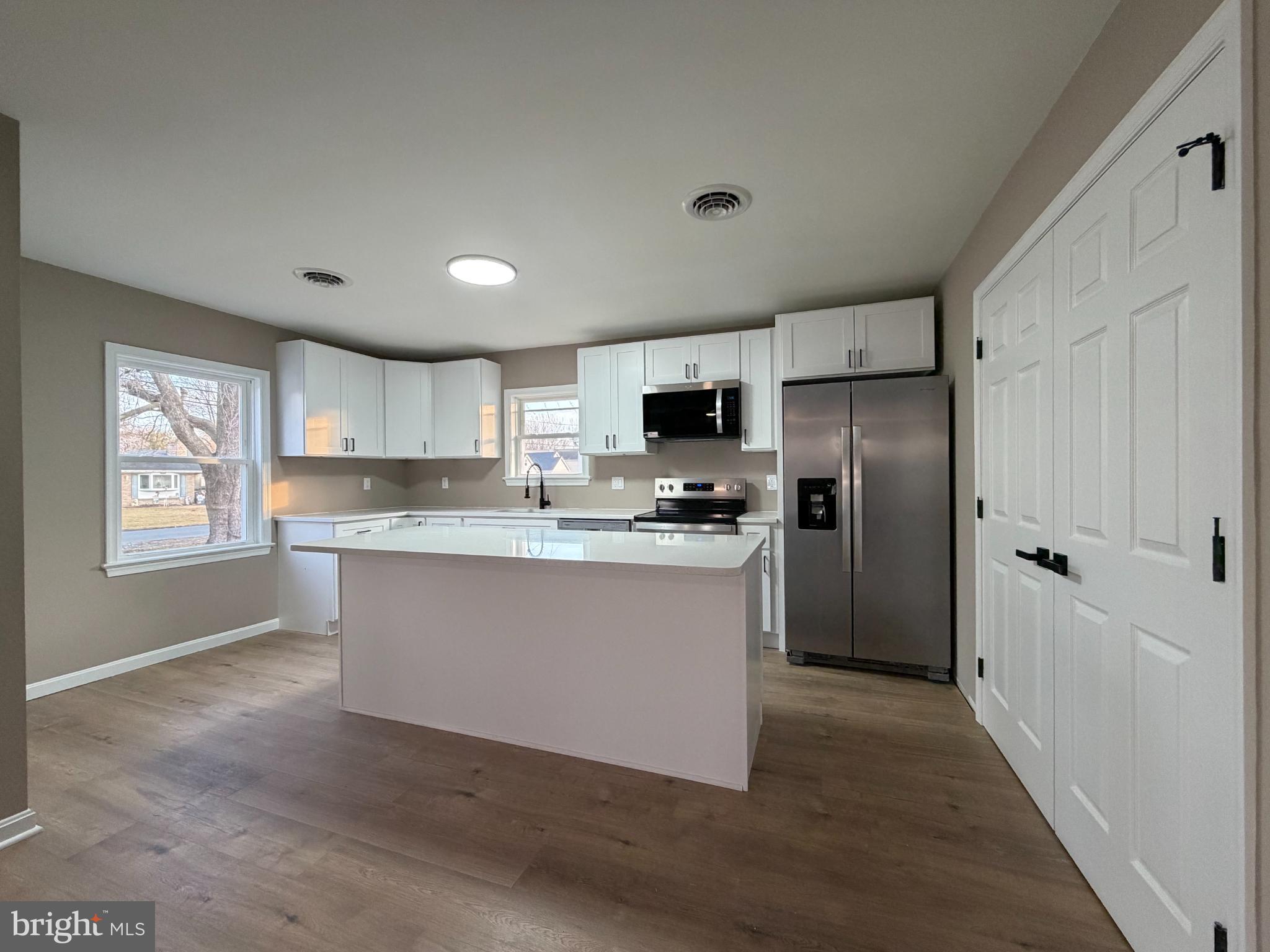 1906 Harbor Drive Chester, MD 21619 - Photo 13 of 44 a large kitchen with cabinets wooden floor and stainless steel appliances