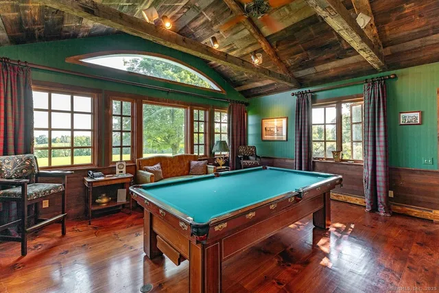 a room with pool table and windows