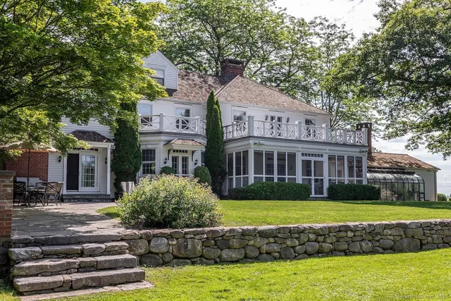 a front view of a house with a garden and swimming pool
