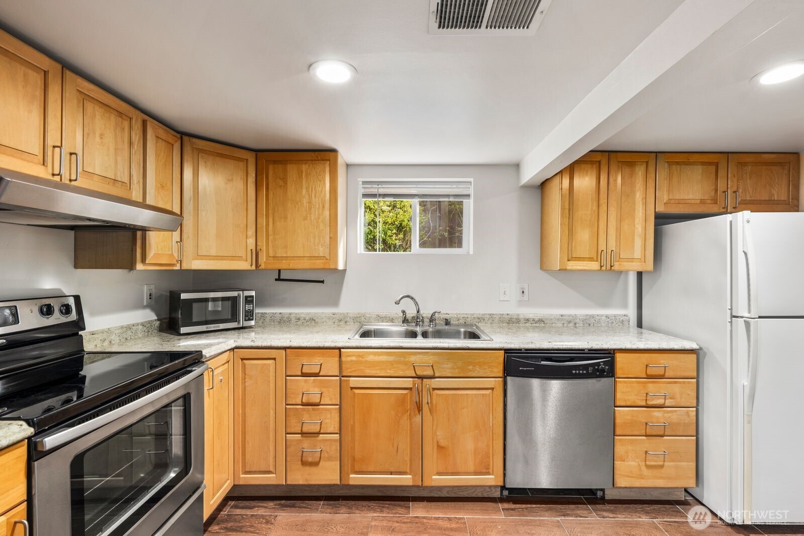6023 35th Avenue Southwest Seattle, WA 98126 - Photo 24 of 38 a kitchen with stainless steel appliances granite countertop a sink stove and refrigerator