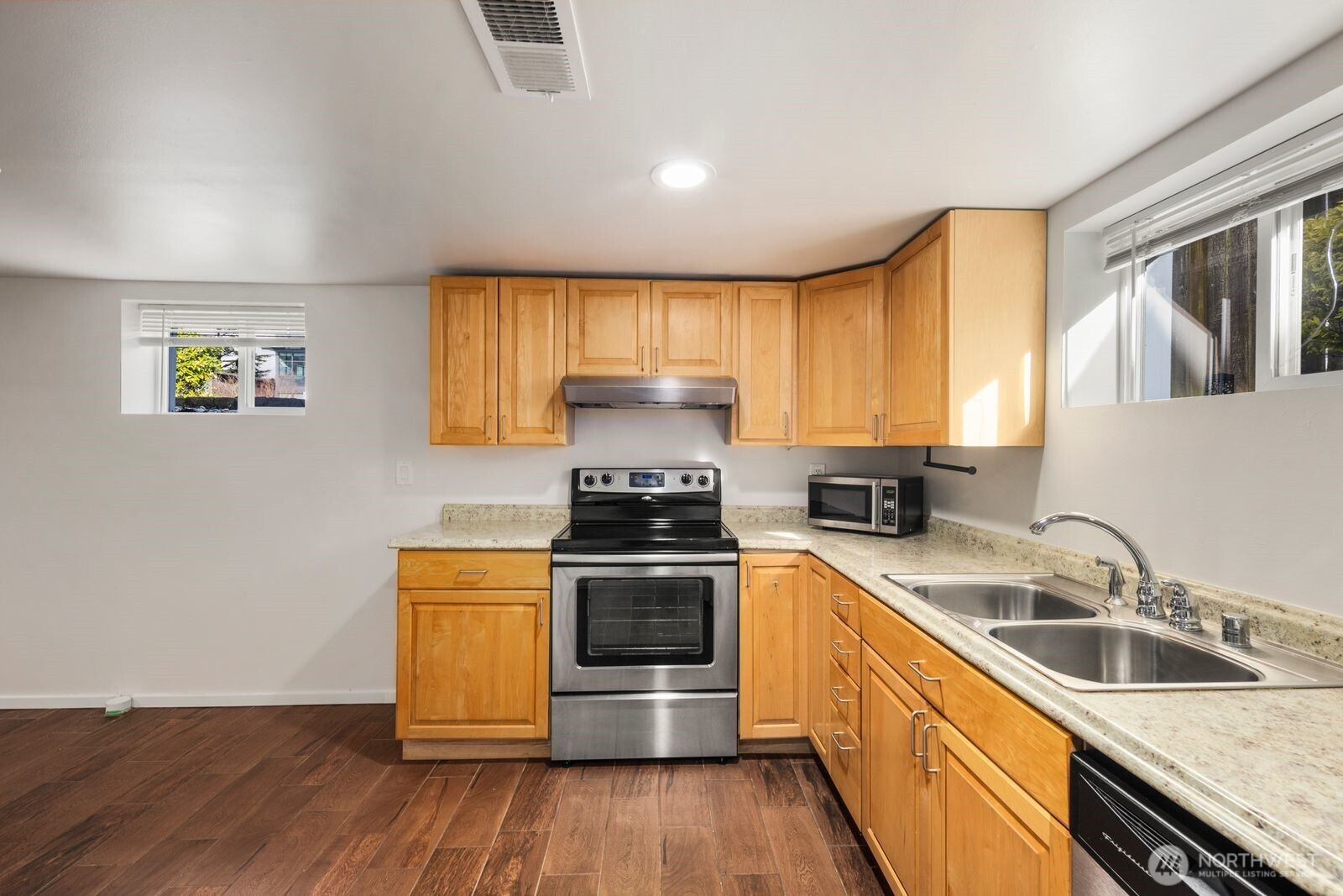 6023 35th Avenue Southwest Seattle, WA 98126 - Photo 25 of 38 a kitchen with a sink wooden floor and stainless steel appliances