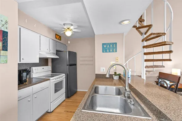 a kitchen with stainless steel appliances granite countertop a sink a stove and a refrigerator
