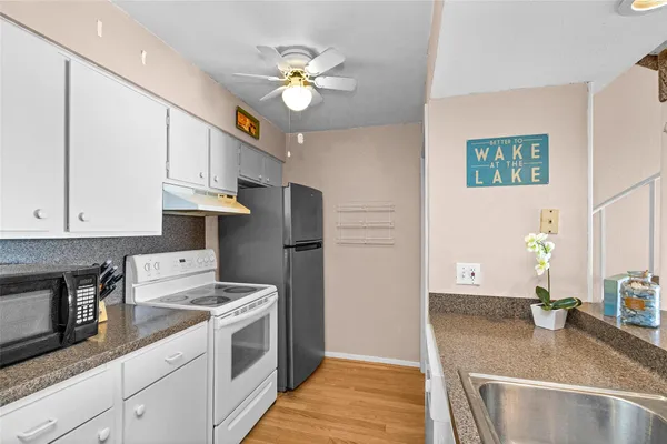 a kitchen with a sink a stove and cabinets