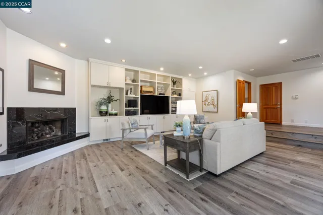a living room with furniture a flat screen tv and a fireplace