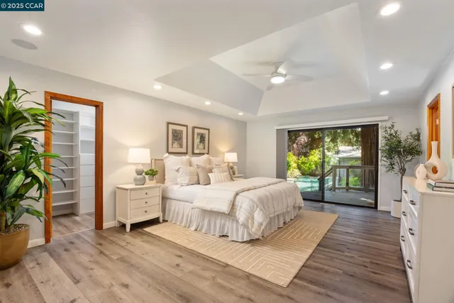 a bedroom with a large bed and a large window with wooden floor
