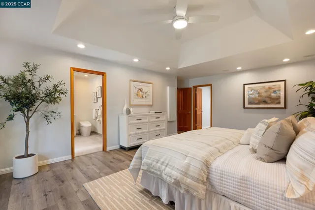 a spacious bedroom with a bed and a potted plant