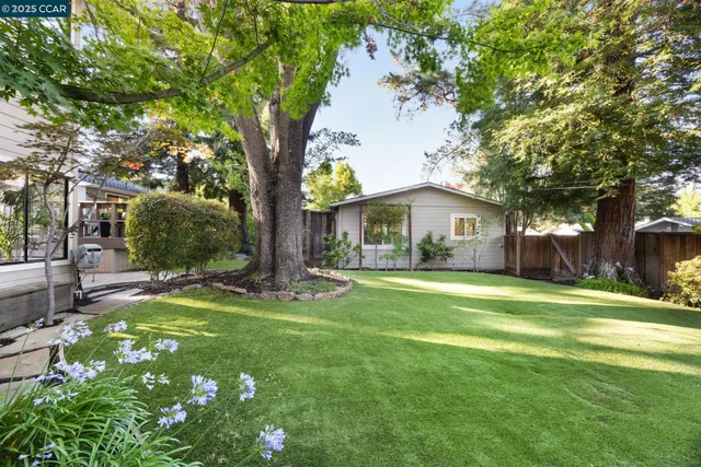 a front view of a house with a garden and trees