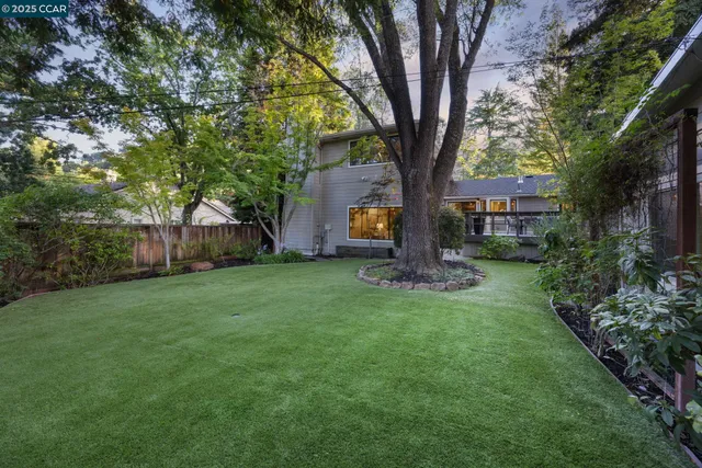 a view of a house with backyard and a tree