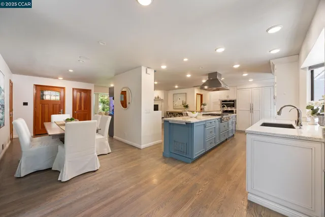 a large living room with stainless steel appliances kitchen island granite countertop a couch and a view of kitchen