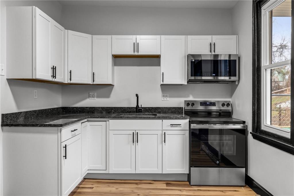 222 East 16th Avenue Homestead, PA 15120 - Photo 11 of 28 a kitchen with stainless steel appliances granite countertop a stove and a white cabinets