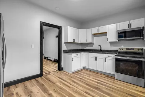 a kitchen with granite countertop white cabinets and stainless steel appliances
