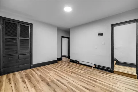 an empty room with wooden floor and closet