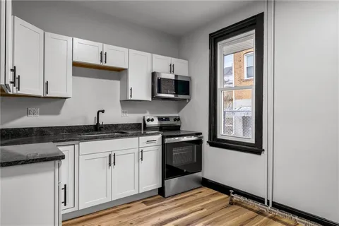 a kitchen with granite countertop a sink and steel appliances
