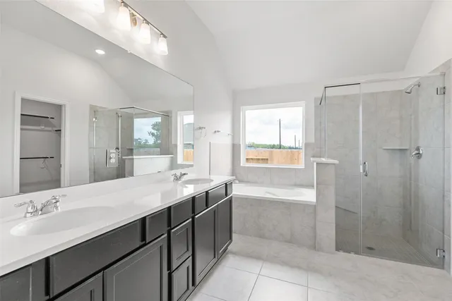 a bathroom with a granite countertop sink a large mirror and a bathtub