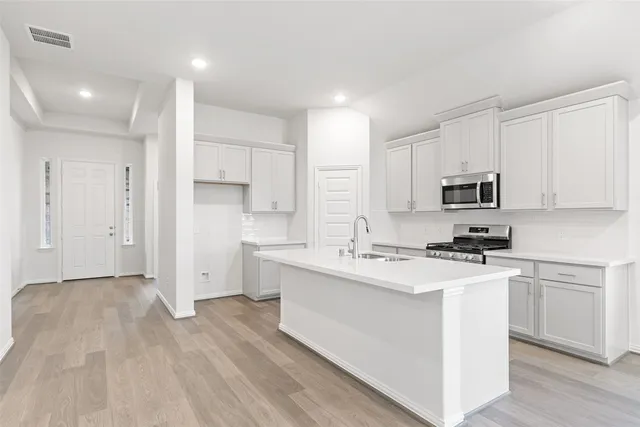 a kitchen with stainless steel appliances granite countertop a sink stove and refrigerator
