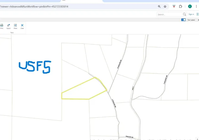 a view of a dry yard with wooden fence