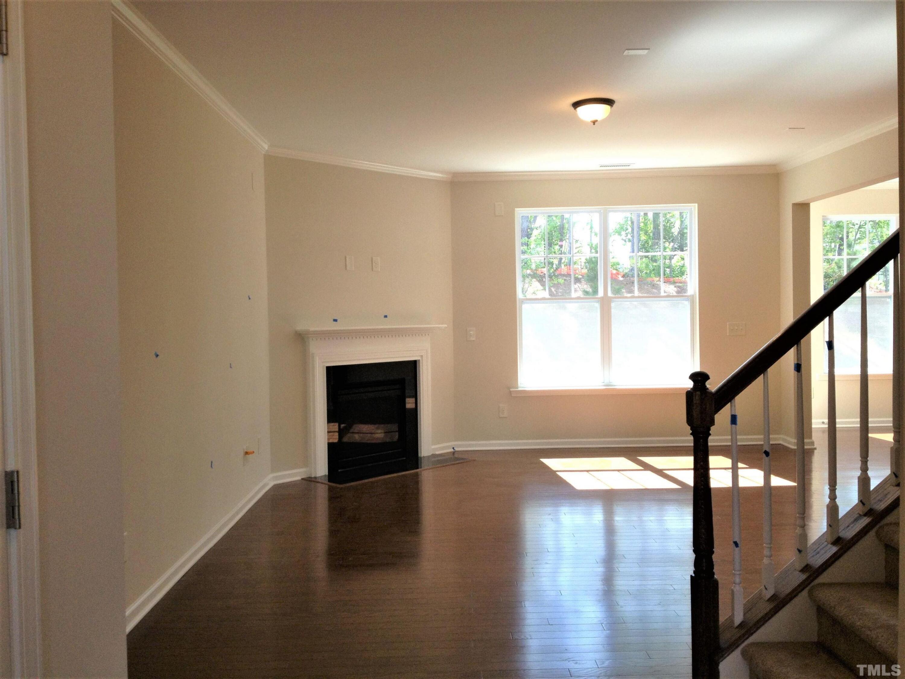 226 Skyros Loop Cary, NC 27519 - Photo 2 of 14 a view of an empty room with wooden floor and a window
