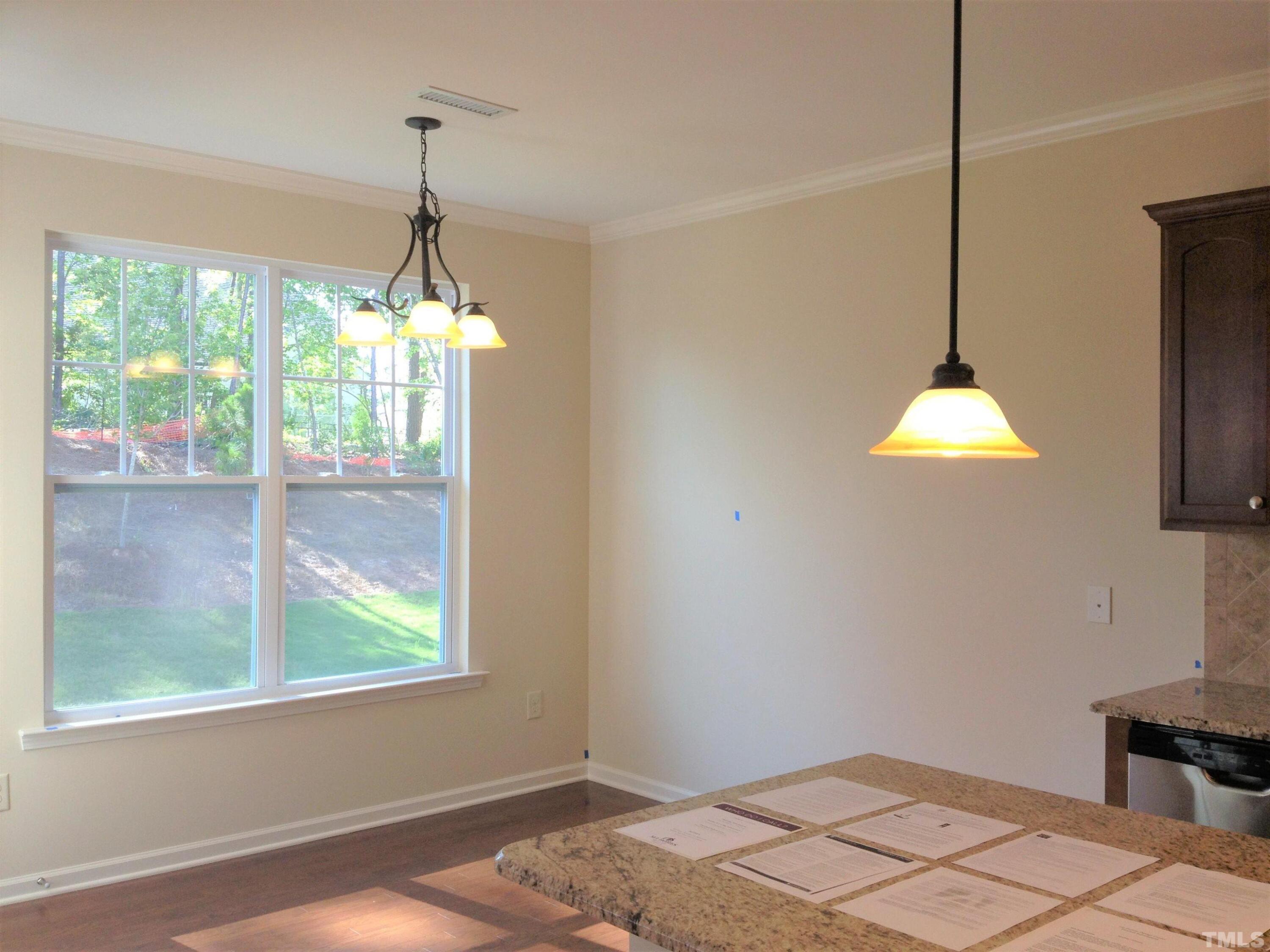 226 Skyros Loop Cary, NC 27519 - Photo 4 of 14 a bedroom with a bed and a chandelier