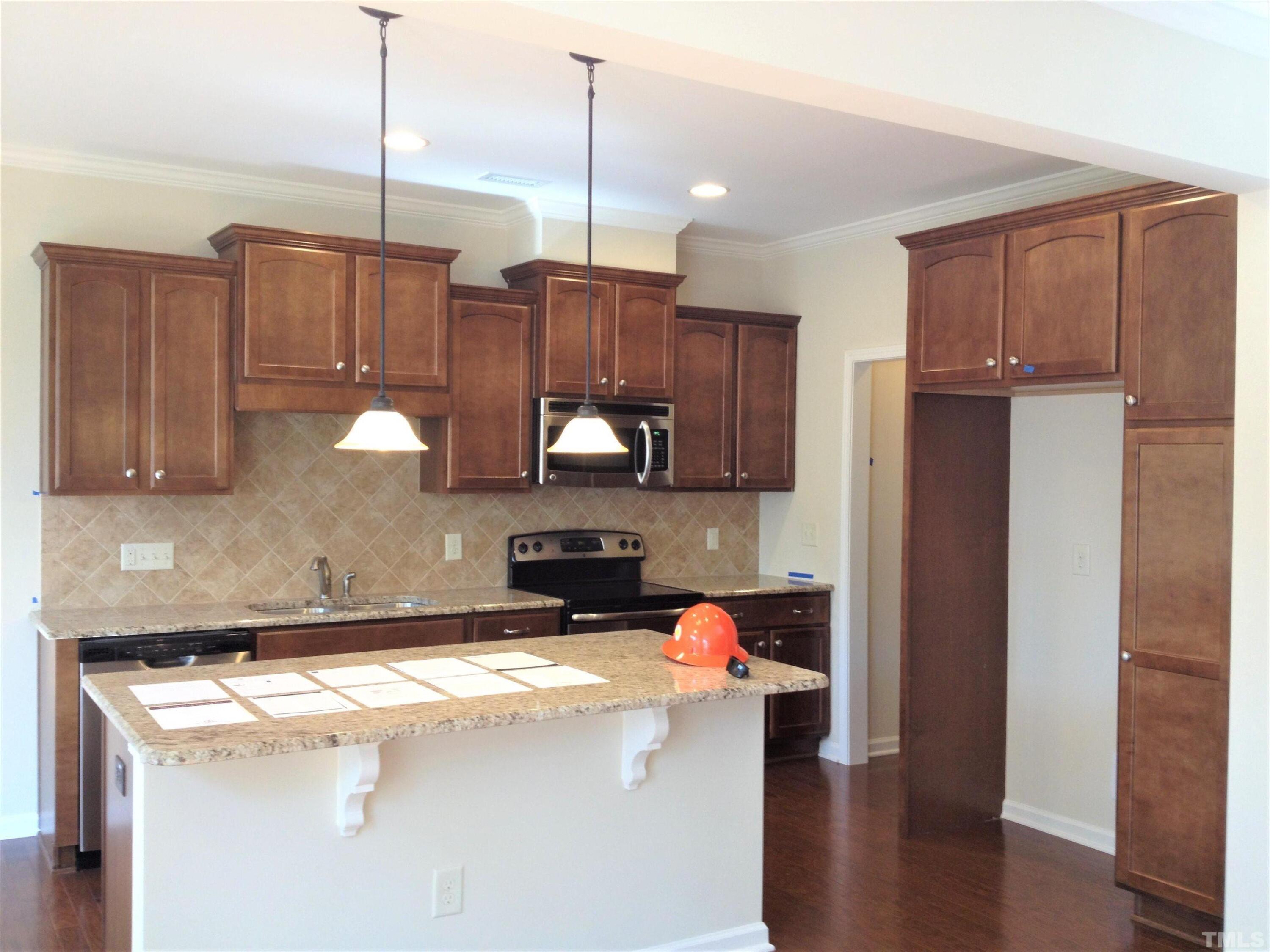226 Skyros Loop Cary, NC 27519 - Photo 5 of 14 a kitchen with stainless steel appliances granite countertop a refrigerator a sink and a stove