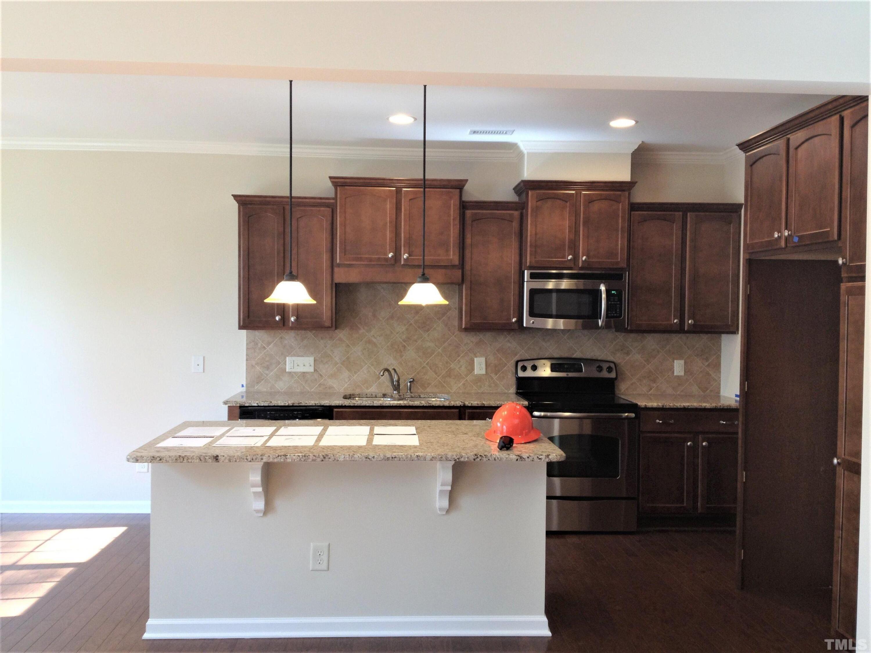 226 Skyros Loop Cary, NC 27519 - Photo 6 of 14 a kitchen with stainless steel appliances granite countertop a sink a stove and a refrigerator