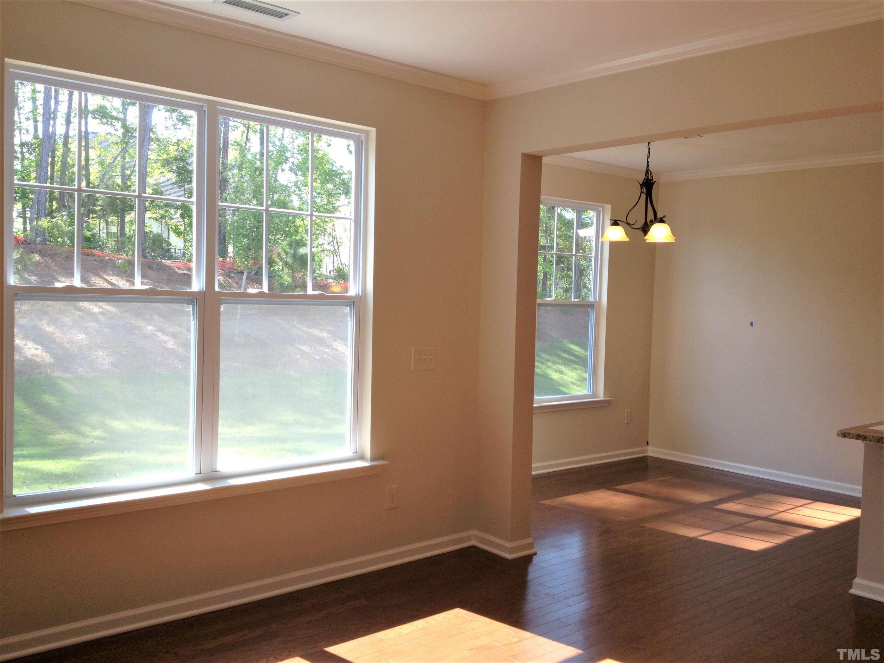 226 Skyros Loop Cary, NC 27519 - Photo 7 of 14 a view of an empty room with wooden floor and a window