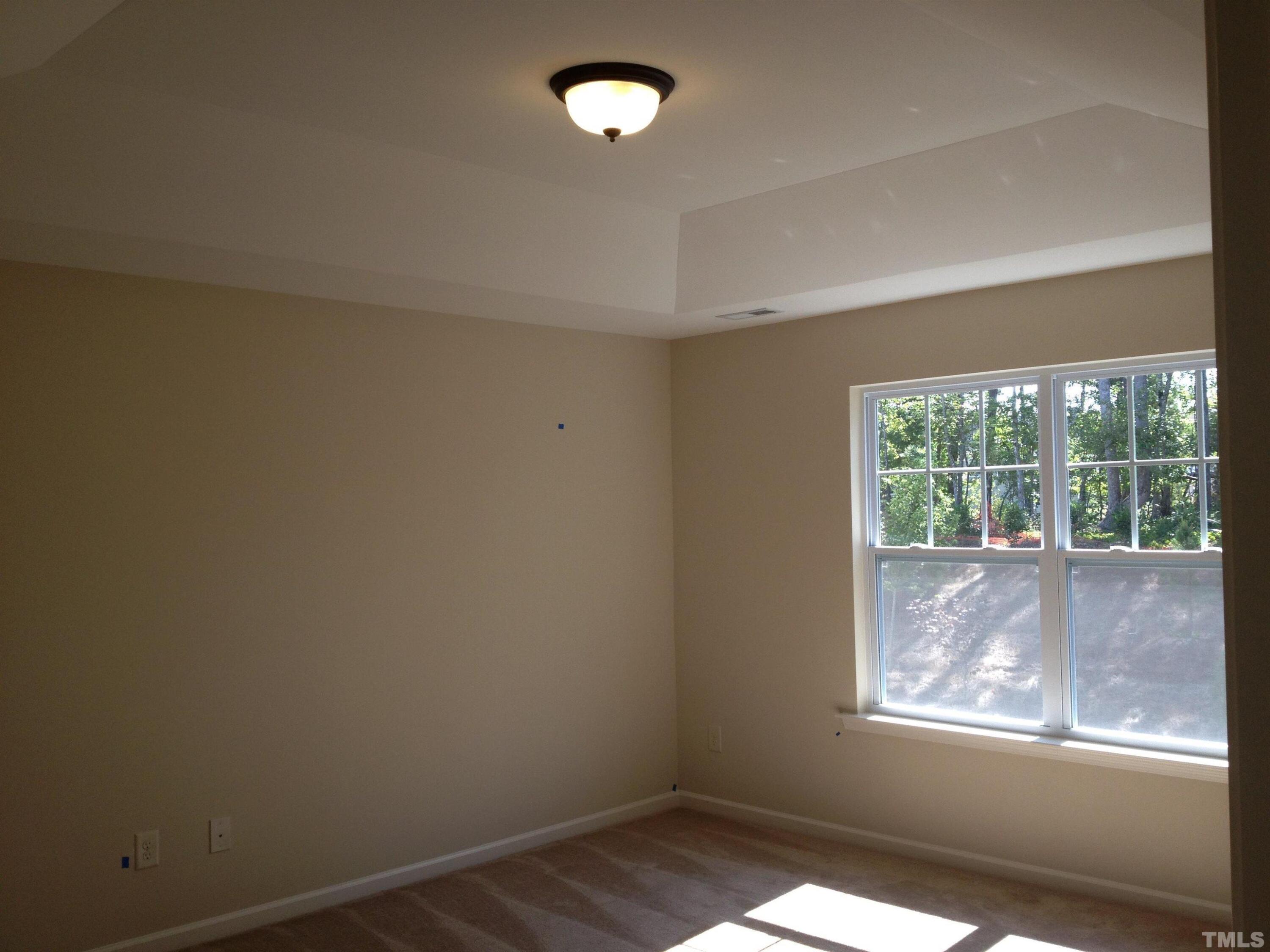 226 Skyros Loop Cary, NC 27519 - Photo 9 of 14 an empty room with wooden floor and windows