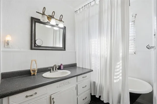 a bathroom with a granite countertop sink and a mirror