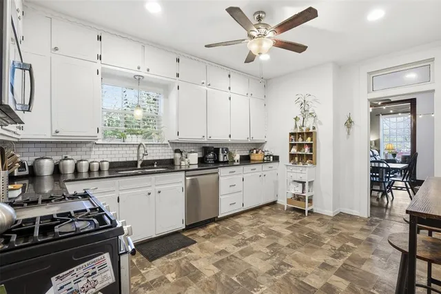 a kitchen with stainless steel appliances granite countertop a stove a sink and a refrigerator