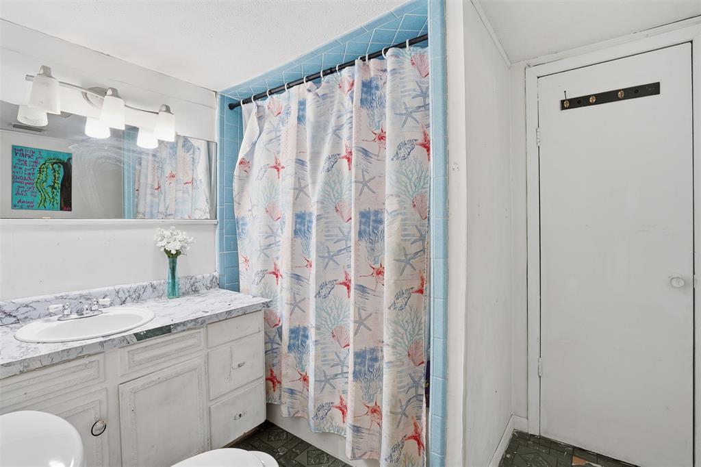 114 S Field Cleburne, TX 76033 - Photo 19 of 23 a bathroom with a sink a vanity and a shower