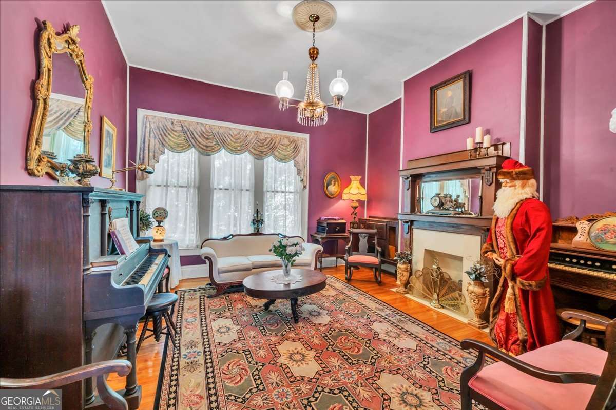 212 East Union Street Vienna, GA 31092 - Photo 10 of 62 a living room with furniture a piano and a chandelier