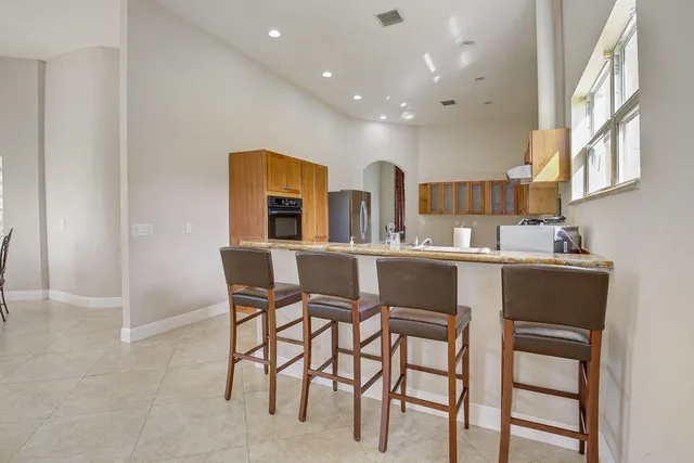 a kitchen with a dining table chairs and cabinets
