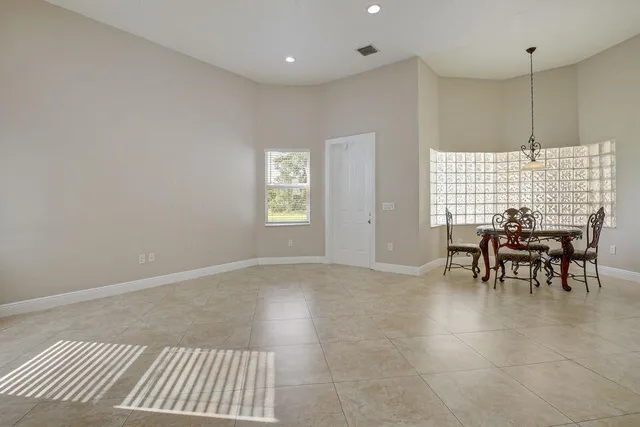 an empty room with kitchen view and a window