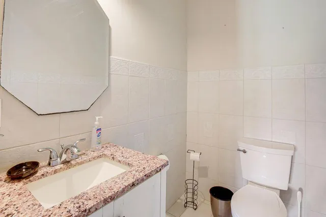a bathroom with a granite countertop sink and a mirror