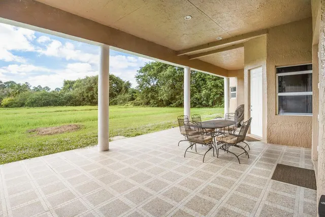 a view of a patio with a table and chairs and potted plants