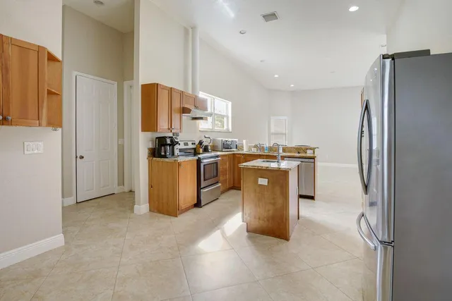 a kitchen with stainless steel appliances furniture a refrigerator a sink a stove top oven and cabinets
