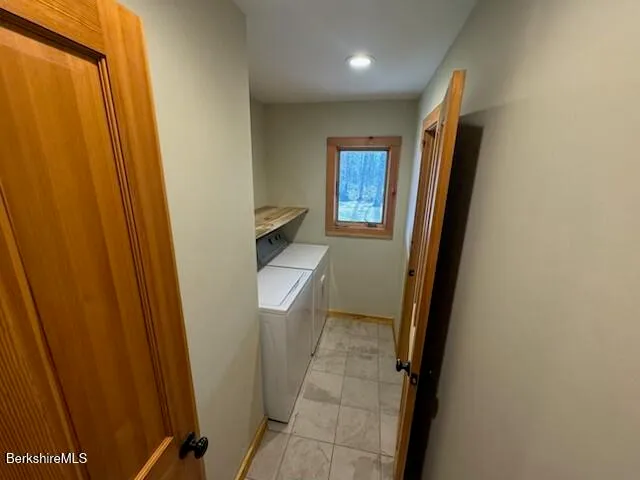 a utility room with a sink a toilet and a mirror