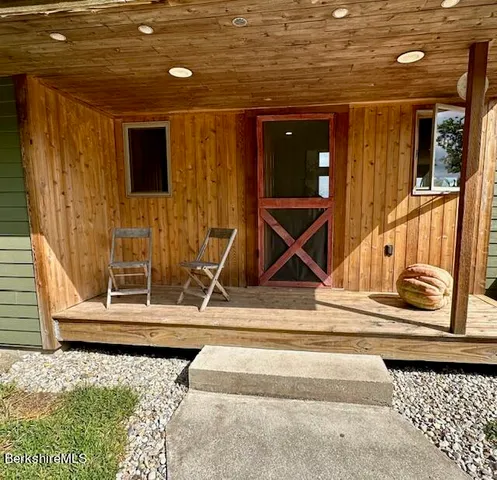 a kitchen with stainless steel appliances kitchen island granite countertop a table chairs sink and cabinets