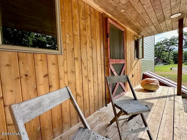 a kitchen with granite countertop a stove a sink dishwasher and white cabinets with wooden floor