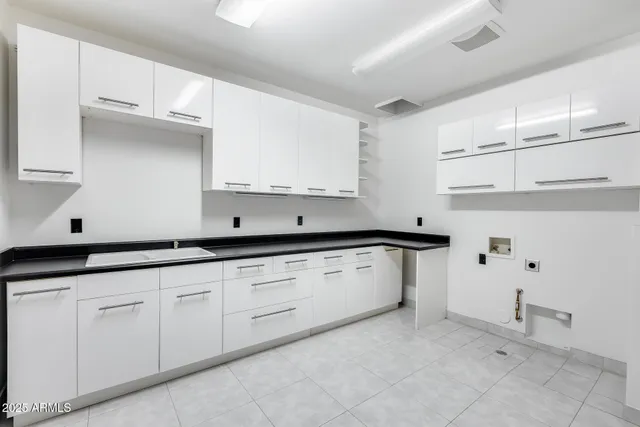 an empty room with wooden floor chandelier fan and windows